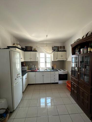 a kitchen with white cabinets and a white refrigerator at Family Apartment in Potamos Kythira in Potamós