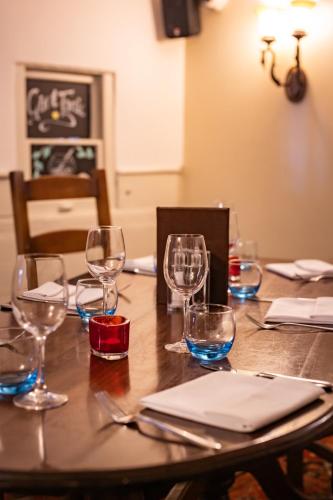 a wooden table with wine glasses on it at The Red Lion Hotel in Hillingdon