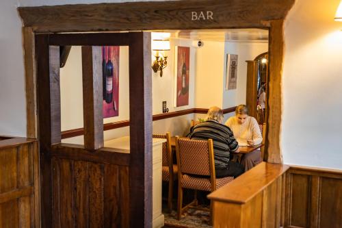 two men sitting at a table in a bar at The Red Lion Hotel in Hillingdon