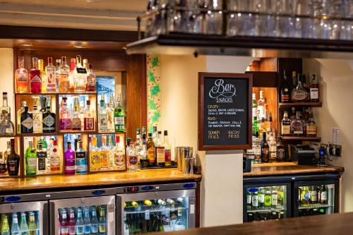 a bar with a lot of bottles of alcohol at The Red Lion Hotel in Hillingdon