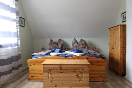 ein Schlafzimmer mit einem Holzbett und einer Holzkommode in der Unterkunft Ferienhaus Kiek Över in Prerow