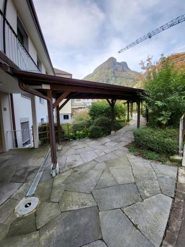 a building with a wooden pavilion next to a mountain at Schöne ruhige Wohnung mit Sicht auf den Innenpark in Gersau