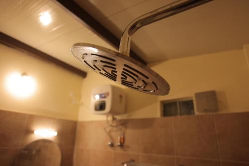 a bathroom with a shower head and a sink at PALM PARADISE Beach Resort in Puducherry