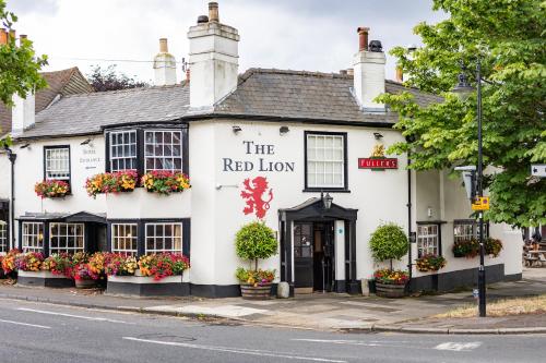 a white building on the corner of a street at The Red Lion Hotel in Hillingdon