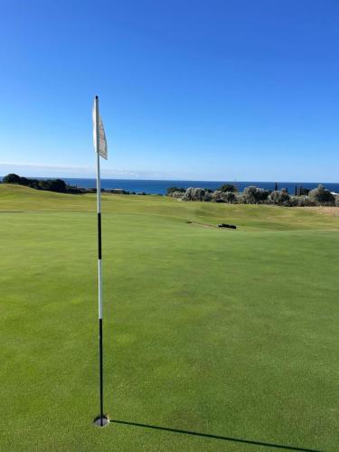 a golf course with a flag in the middle of a green at Ocean View 1111 Retreat in Rikia