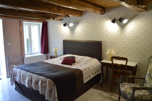 ein Schlafzimmer mit einem Bett, einem Tisch und einem Stuhl in der Unterkunft Le Moulin au Fil de l'Eau in Verseilles-le-Bas