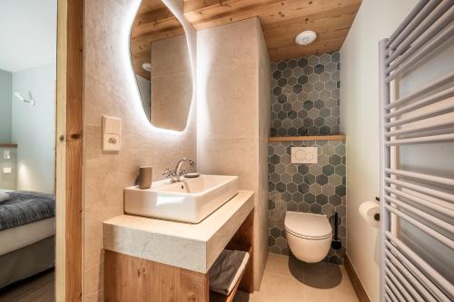 une salle de bain avec un lavabo et des toilettes dans l'établissement CHALET PASCAL A02 : Splendide T4 neuf avec jardin privatif et jacuzzi, à Morzine