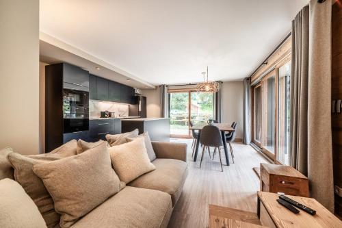 un salon avec un canapé et une table dans l'établissement CHALET PASCAL A02 : Splendide T4 neuf avec jardin privatif et jacuzzi, à Morzine