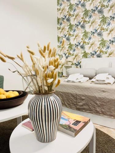 a black and white vase with flowers on a table at Butera Apartments Luxury in Palermo