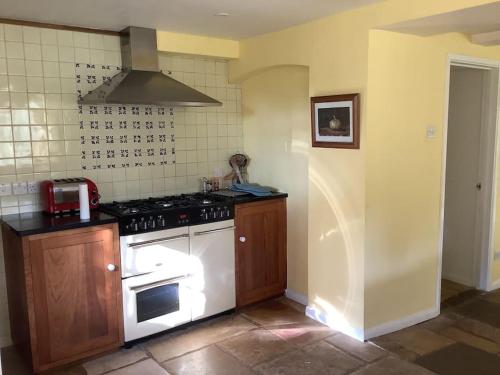 a kitchen with a stove top oven in a room at The Snicket in Cheltenham