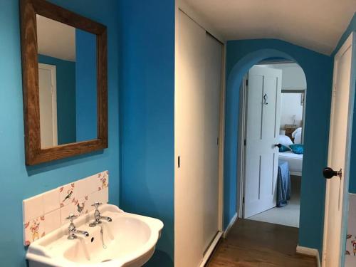 a bathroom with a white sink and a mirror at The Snicket in Cheltenham