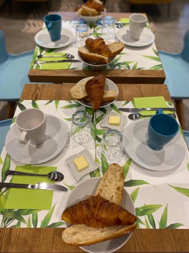 - une table avec des assiettes de nourriture et de pain dans l'établissement CHAMBRES D'HOTES Chez Nicole et Christian, à Villaz