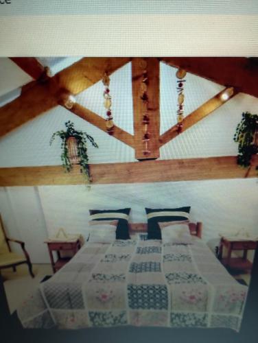 a bedroom with two beds in a room with wooden ceilings at Entre mer et cevennes in Boisseron