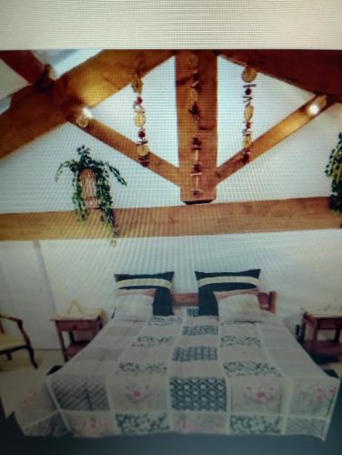 une chambre avec deux lits dans une pièce avec des plafonds en bois dans l'établissement Entre mer et cevennes, à Boisseron