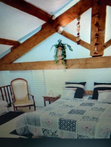 - une chambre avec un lit et un plafond aux poutres apparentes dans l'établissement Entre mer et cevennes, à Boisseron