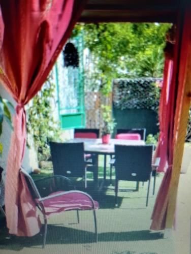 d'une terrasse avec des chaises, une table, une table et des chaises. dans l'établissement Entre mer et cevennes, à Boisseron