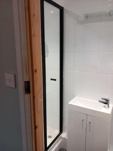 a bathroom with a mirror and a sink at The Nook- Cotswold guest room in Mickleton