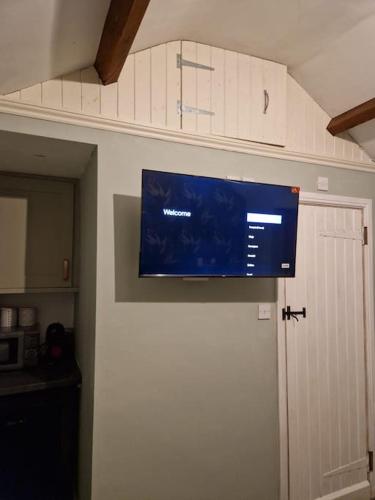 a flat screen tv hanging from a wall in a kitchen at The Nook- Cotswold guest room in Mickleton