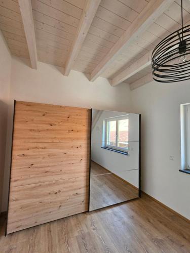 a large wooden door in a room with a mirror at Moderne,ruhige Ferienwohnung in Eicherloh in Finsing