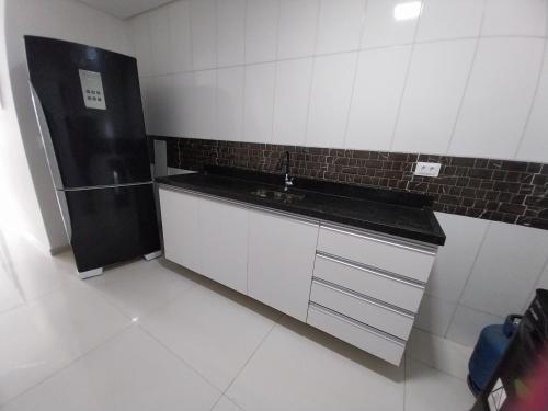 a kitchen with a sink and a refrigerator at Espaço Brisa do Mar in Olinda