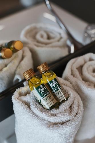 two bottles of essential oils sitting on top of towels at Agriturismo Zapparè Farm Hotel in Trevignano
