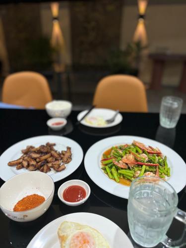 a black table with plates of food on it at patong v hotel in Patong Beach