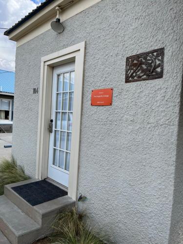 a white building with a door and a sign on it at Dragonfly Cottage 1 of 5 listings downtown in Alpine