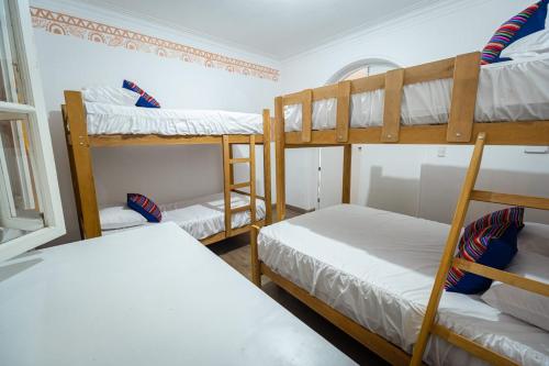 a room with three bunk beds and a window at CASA ÁGUILA y CÓNDOR in Lima