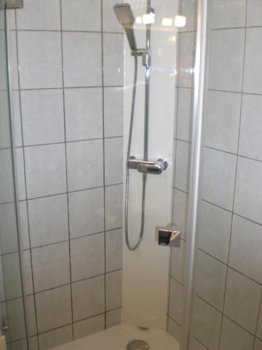 une douche avec une porte vitrée dans une salle de bain dans l'établissement La Roseraie, campagne, calme et paix, à Bulson