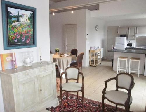 un salon avec une table et des chaises et une cuisine dans l'établissement Maison charmante à Châteney avec piscine partagée, à Châteney