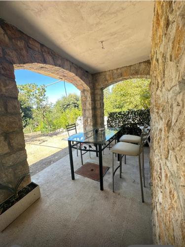 une table et des chaises sur une terrasse avec un mur en pierre dans l'établissement Très rare! Bel appartement 38 m2 Domaine prive, à Vallauris