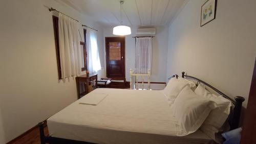 a bedroom with a white bed in a room at Lesvos Tower House Komninos in Sígrion