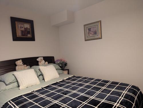 a bedroom with a bed with two teddy bears on it at Bright Room full of love and warmth in Bowmanville