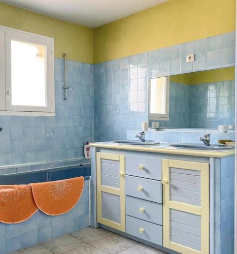 une salle de bain avec un lavabo et un miroir dans l'établissement Le Balcon bleu de Biscarrosse, à Biscarrosse