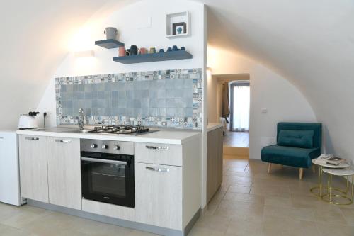 a kitchen with a stove and a blue tile wall at La Scala del Borgo in Cisternino