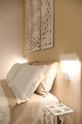 a bed with a white pillow and a side table at La Scala del Borgo in Cisternino