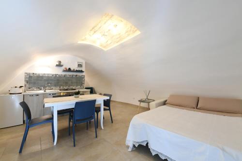 a room with a bed and a table and a kitchen at La Scala del Borgo in Cisternino