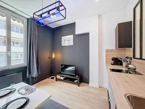 Il dispose d'une cuisine et d'un salon avec une table et une télévision. dans l'établissement My home jean claude vivant 1, à Villeurbanne