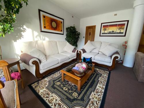 a living room with a white couch and a table at Hotel Küyen-Ko Pucón in Pucón