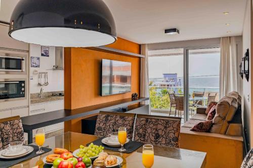 a kitchen with a table with a bowl of fruit on it at Boulevard Bombinhas - Apto em Condomínio com Piscina e Jacuzzi in Bombinhas