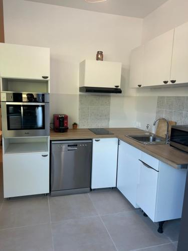 - une cuisine avec des placards blancs et un lave-vaisselle en acier inoxydable dans l'établissement Location appartements 2 pièces, aux Pennes-Mirabeau
