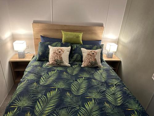 a bedroom with a bed with a blue comforter and two lamps at Sanctuary Shores Newbiggin on Sea in Woodhorn