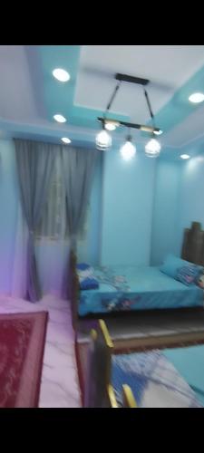 a room with three beds in a room with lights at شقة فندقية للايجار in Nazlat as Sammān