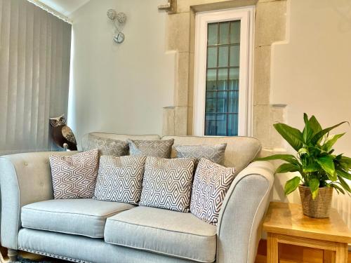 a couch with pillows on it in a living room at Southlands B&B in Bourton on the Water
