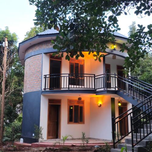 a house with a balcony on the side of it at Tusubira village in Jinja