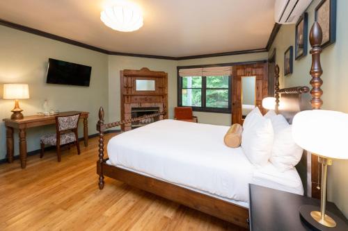 a bedroom with a bed and a desk and a table at The Constance by The Lenox Collection in Lenox