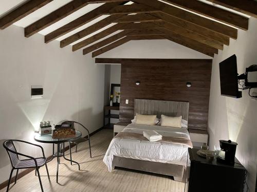 une chambre avec un lit et une table avec des chaises dans l'établissement Cabañas Tahamí con jacuzzi cerca al Aeropuerto, à Guarne