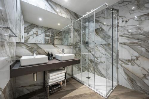 a bathroom with two sinks and a shower at IH Hotels Milano Centrale in Milan