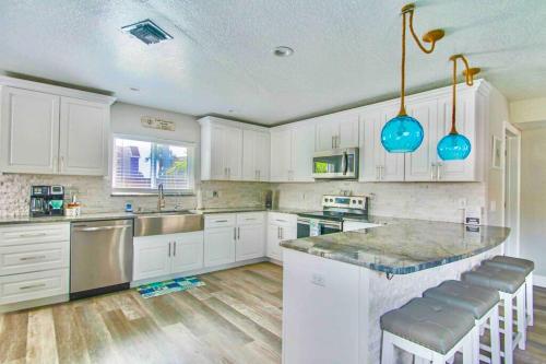 a kitchen with white cabinets and a large island at Spacious 4BR Beach House with Stunning Ocean Views in Cape Canaveral