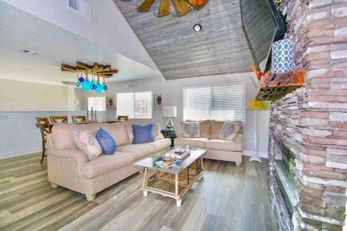 a living room with a couch and a stone wall at Spacious 4BR Beach House with Stunning Ocean Views in Cape Canaveral